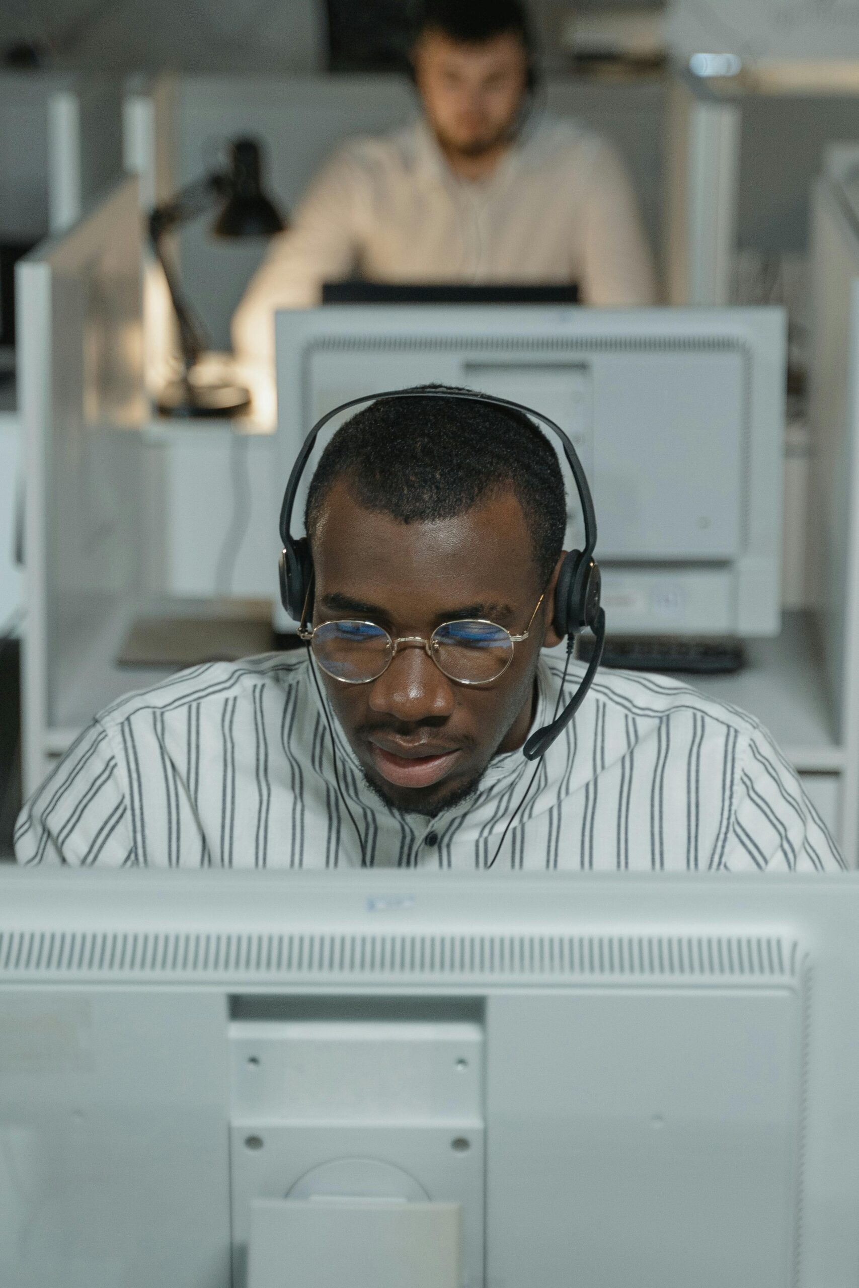 African American call center agent working intently with headset.